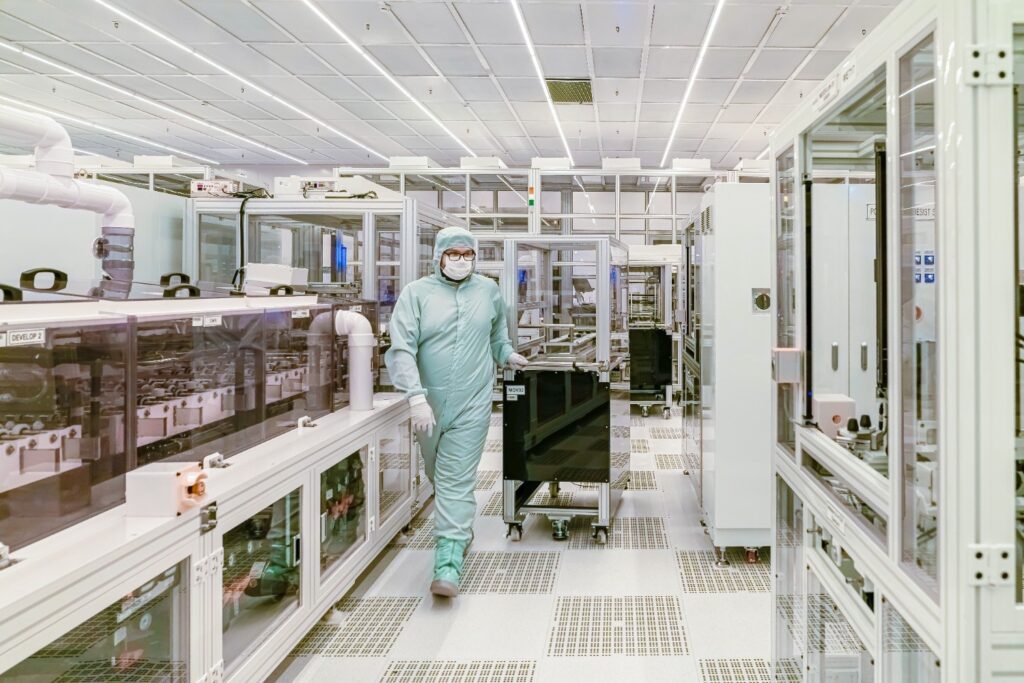 Worker in a protective suit inside a cleanroom facility