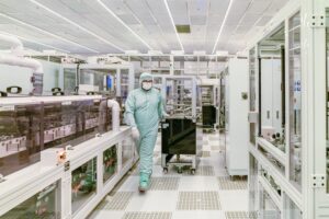 Worker in a protective suit inside a cleanroom facility